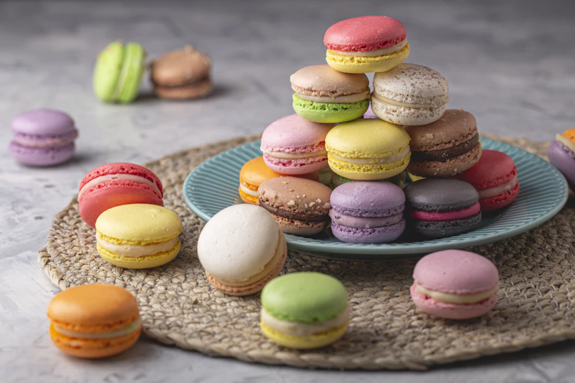 a plate that has a bunch of different colored macaroons on it