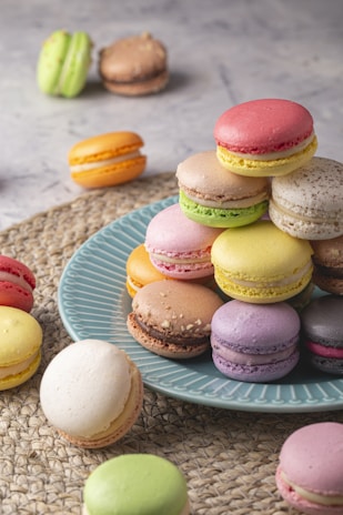 A colorful assortment of macarons arranged neatly on a rustic wooden board.
