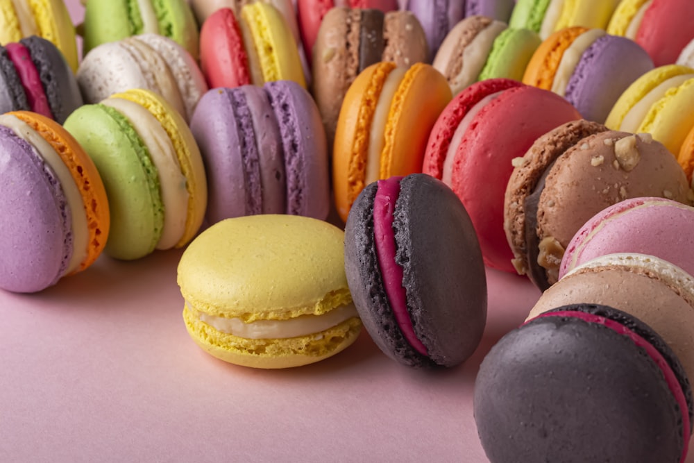 a group of macaroons sitting on top of a pink surface