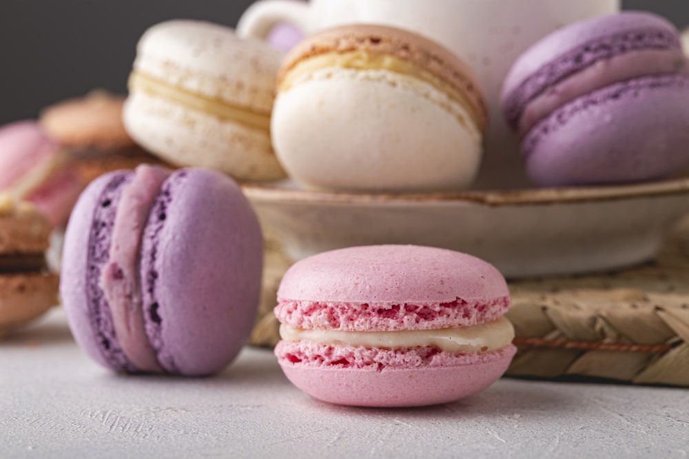 a plate of macaroons sitting next to a bowl of macaroons