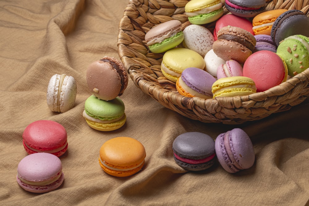 a basket filled with different colored macaroons on top of a table