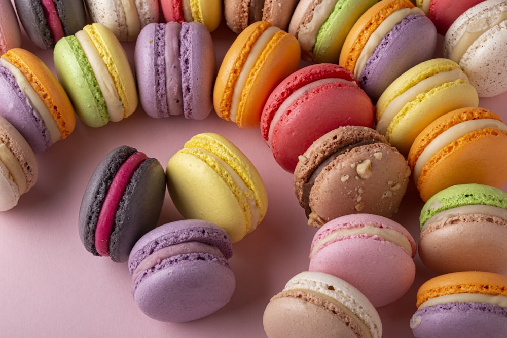 a group of macaroons sitting on top of a pink surface