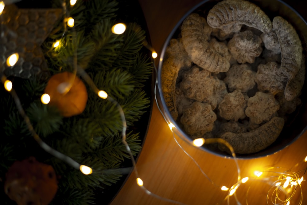 a bowl filled with cookies next to a christmas tree