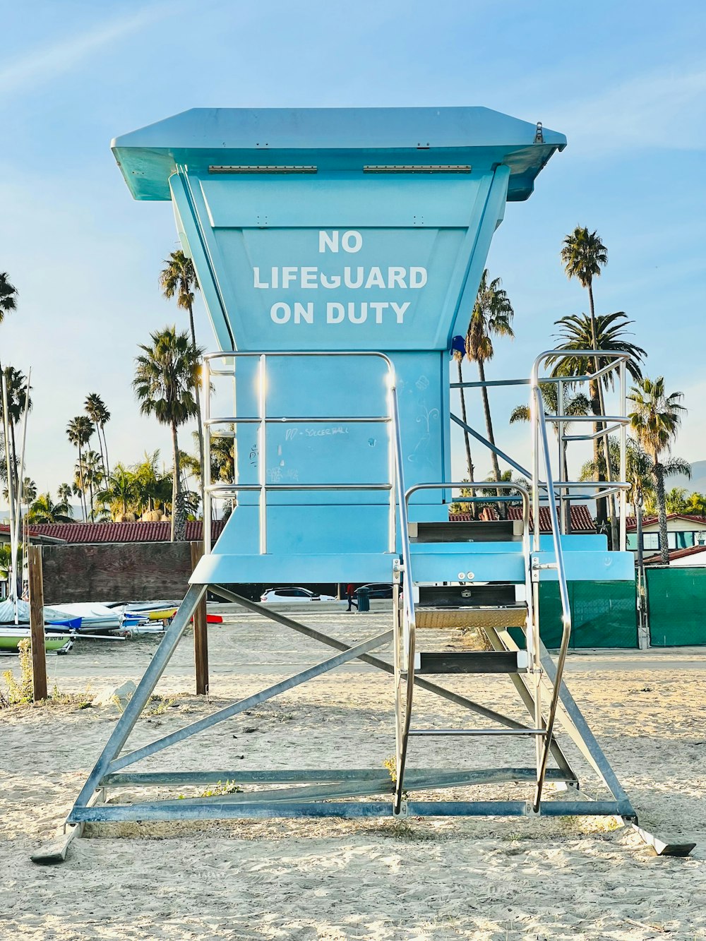 a lifeguard chair on the beach with palm trees in the background