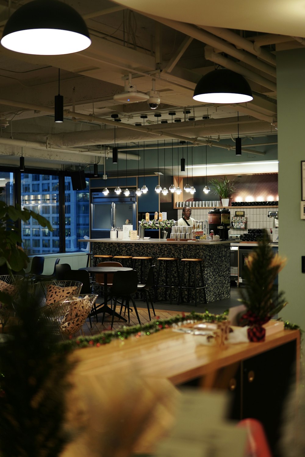 a restaurant with tables and chairs and lights hanging from the ceiling