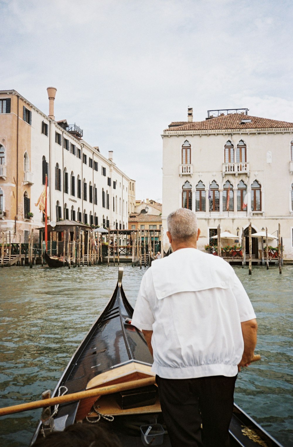 a man riding a boat down a river next to tall buildings