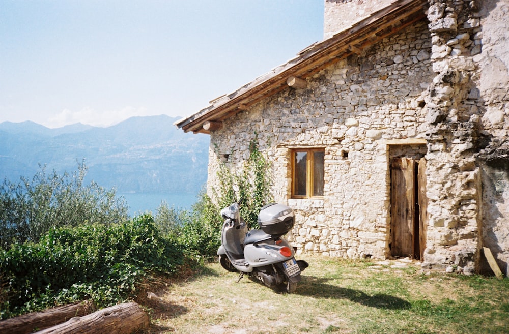 a motor scooter parked in front of a stone building