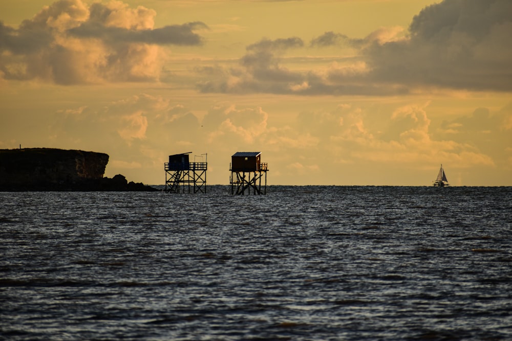 a couple of lifeguard towers sitting on top of a body of water