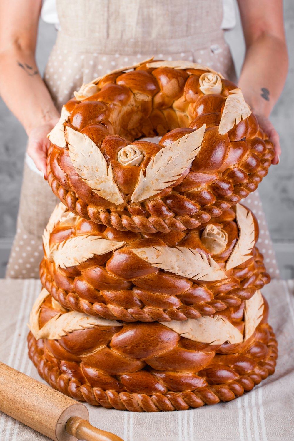 a woman standing next to a stack of bread