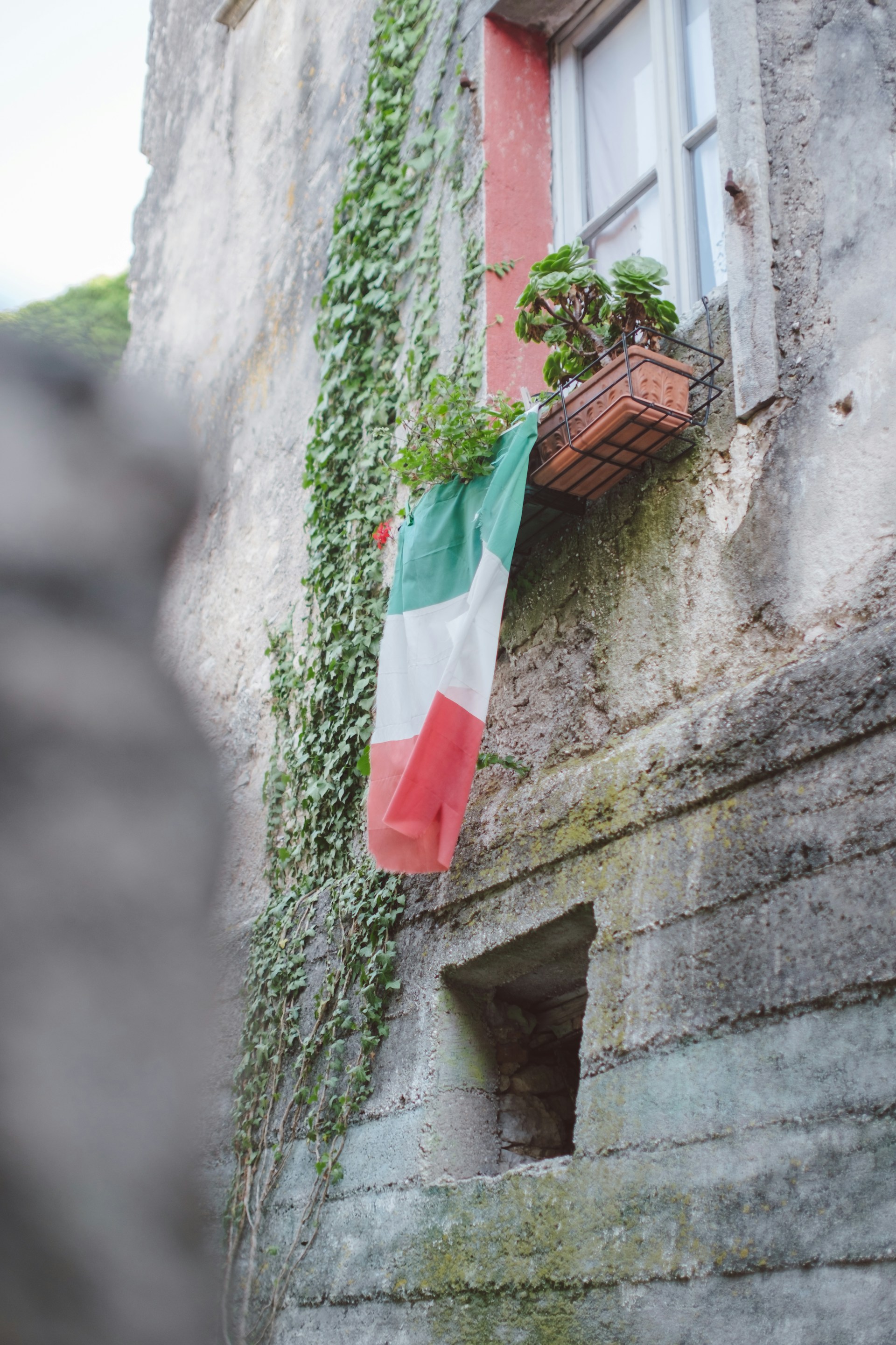 a flag hanging from a window of a building