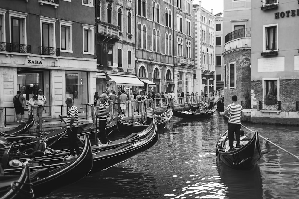 a black and white photo of gondolas on a canal