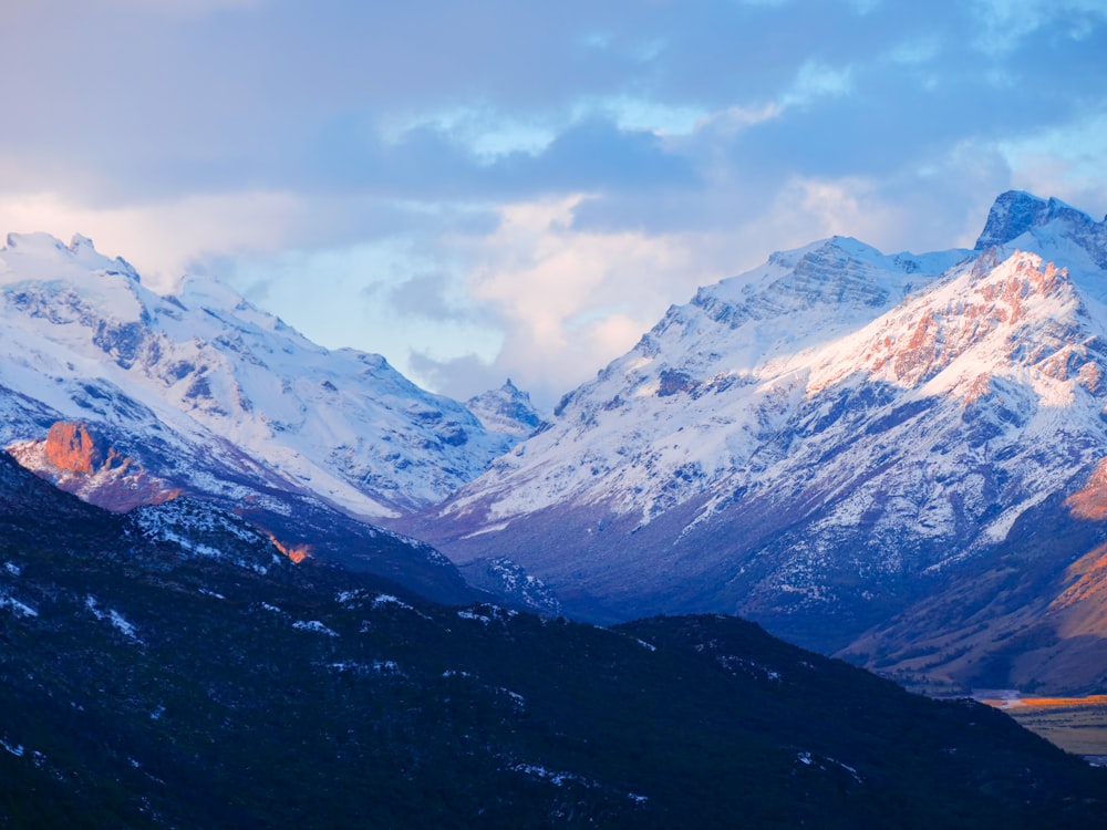 a mountain range with snow covered mountains in the background