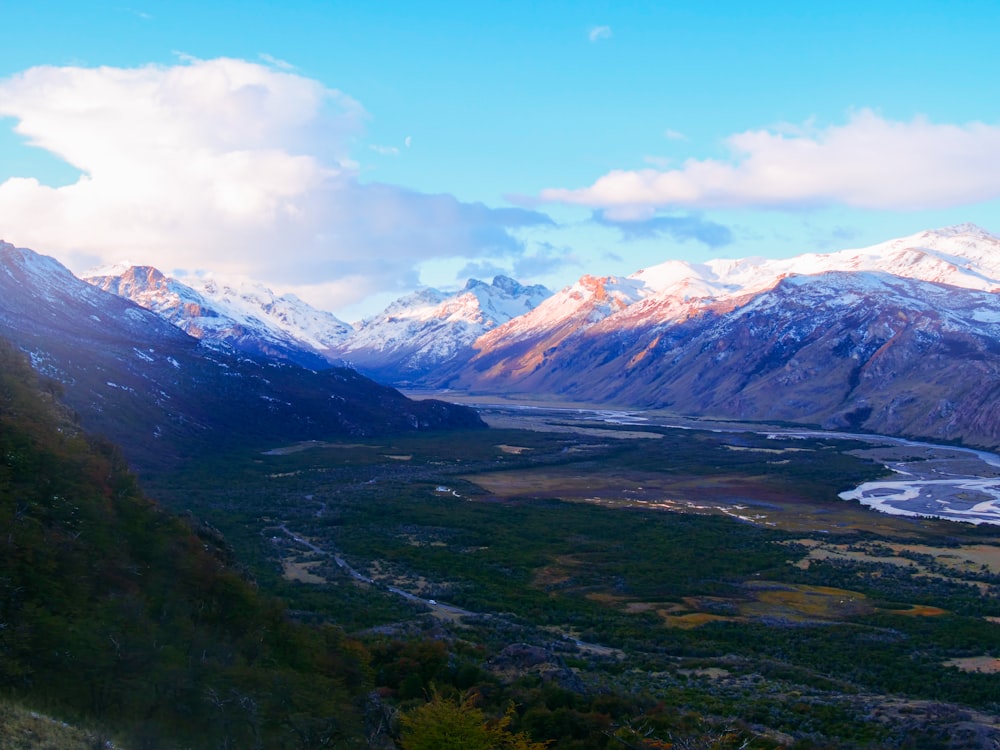 a scenic view of a valley with mountains in the background