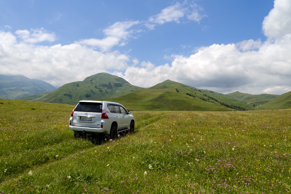 a car parked in a field with mountains in the background