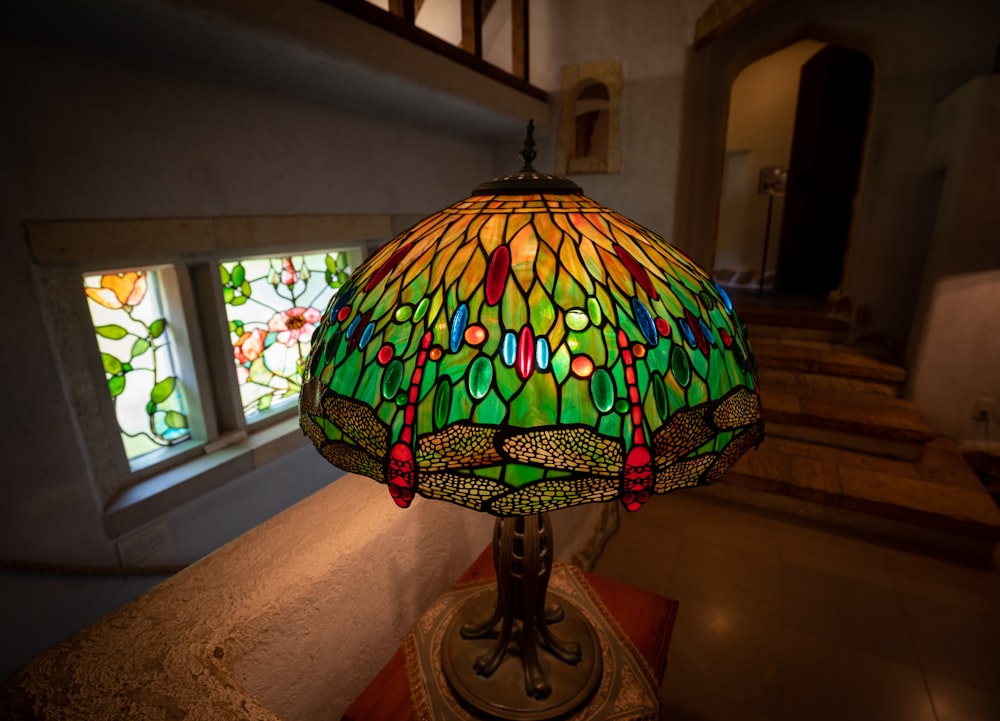 a stained glass lamp sitting on top of a table
