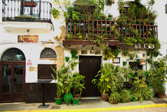 View of the restored casarão’s charming facade with greenery and welcoming entrance in Belo Horizonte.