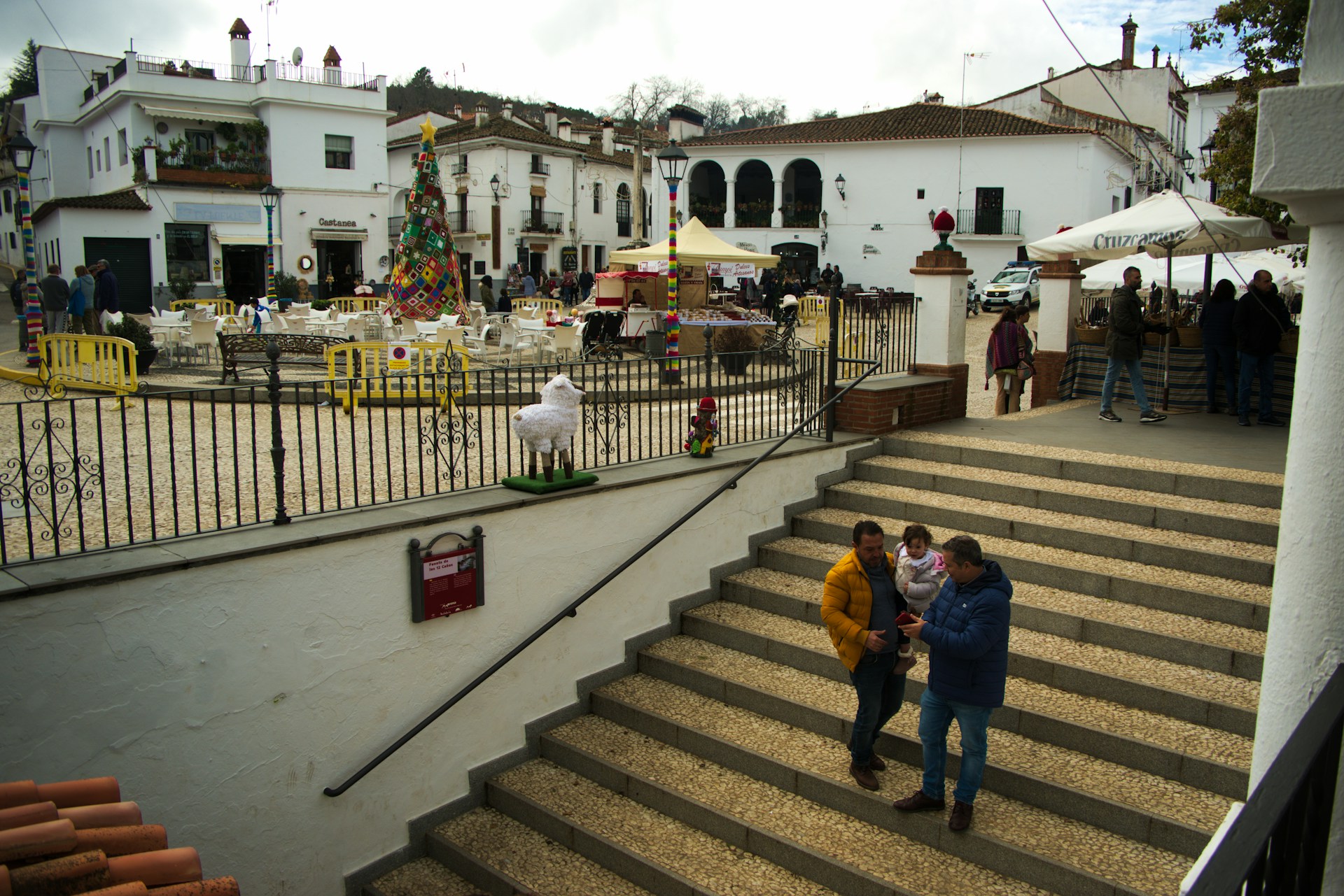 Children gathered around a beautifully decorated Christmas tree in the town square of Moralzarzal.