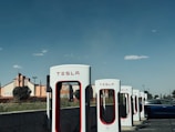 Wide shot of a commercial building parking lot with multiple EV chargers installed and ready for use