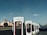 Photo of a busy parking lot with electric vehicle charging stations in use.