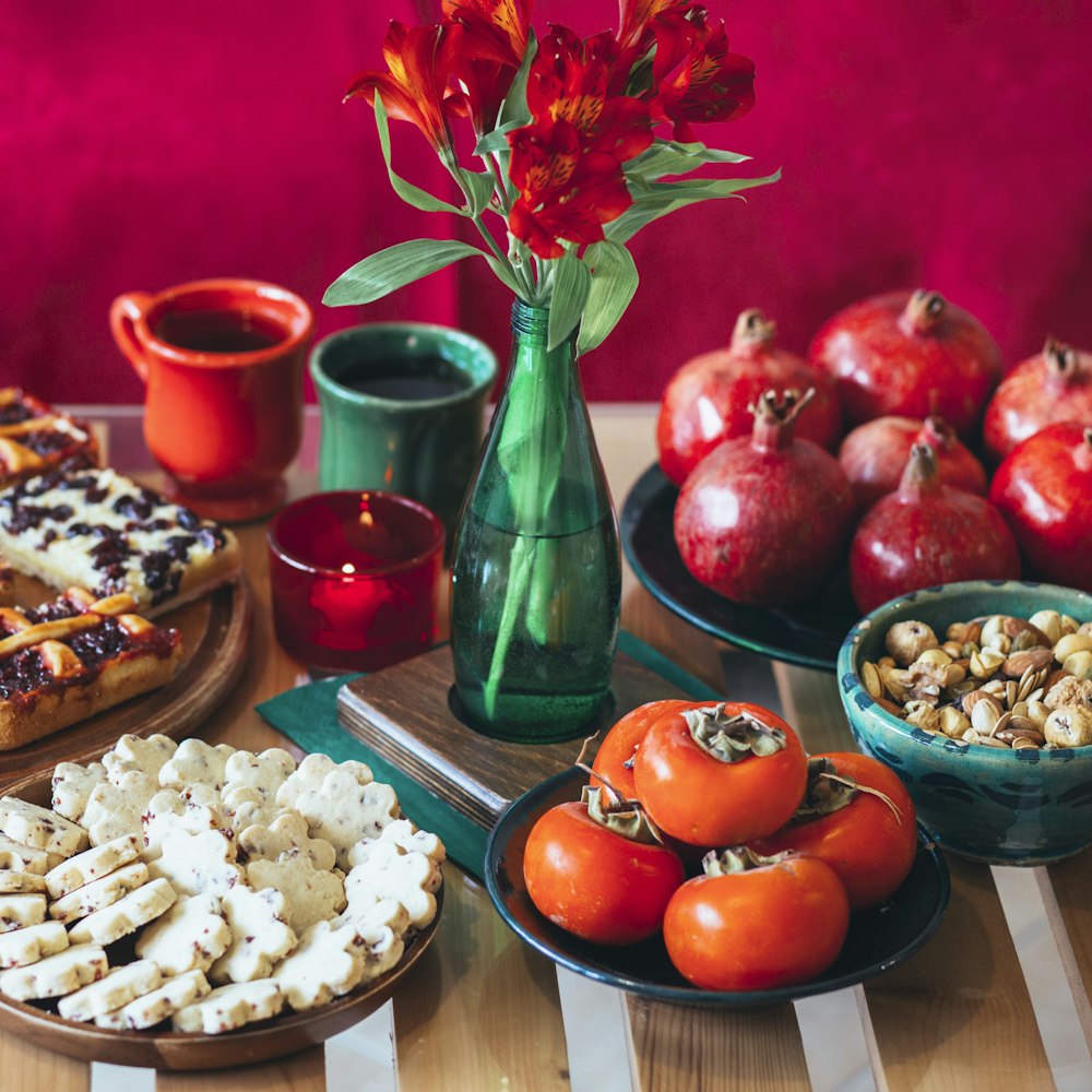 a table topped with plates of food and a vase filled with flowers