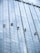 Several workers are suspended on ropes, cleaning the windows of a tall, glass-covered skyscraper.
