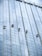Several workers are suspended on ropes, cleaning the windows of a tall, glass-covered skyscraper.
