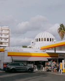 Placeholder image showing a modern gas station design with clean angles and bold yellow accents.