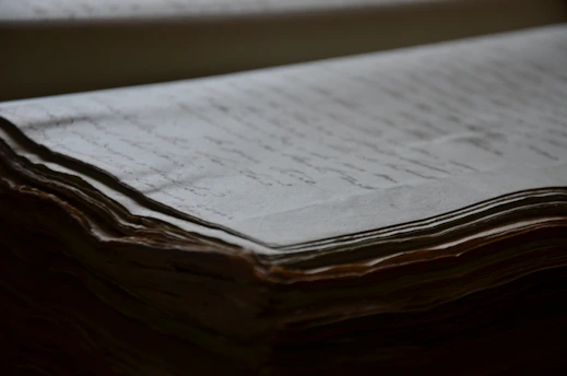 A close-up of old papers and manuscripts being carefully handled in an archive