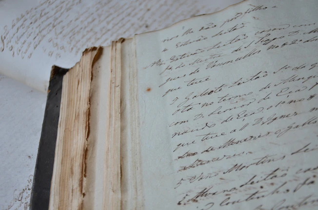 A close-up of hands holding a weathered journal, symbolizing stories passed down.