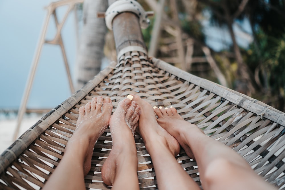 a person laying in a hammock on the beach