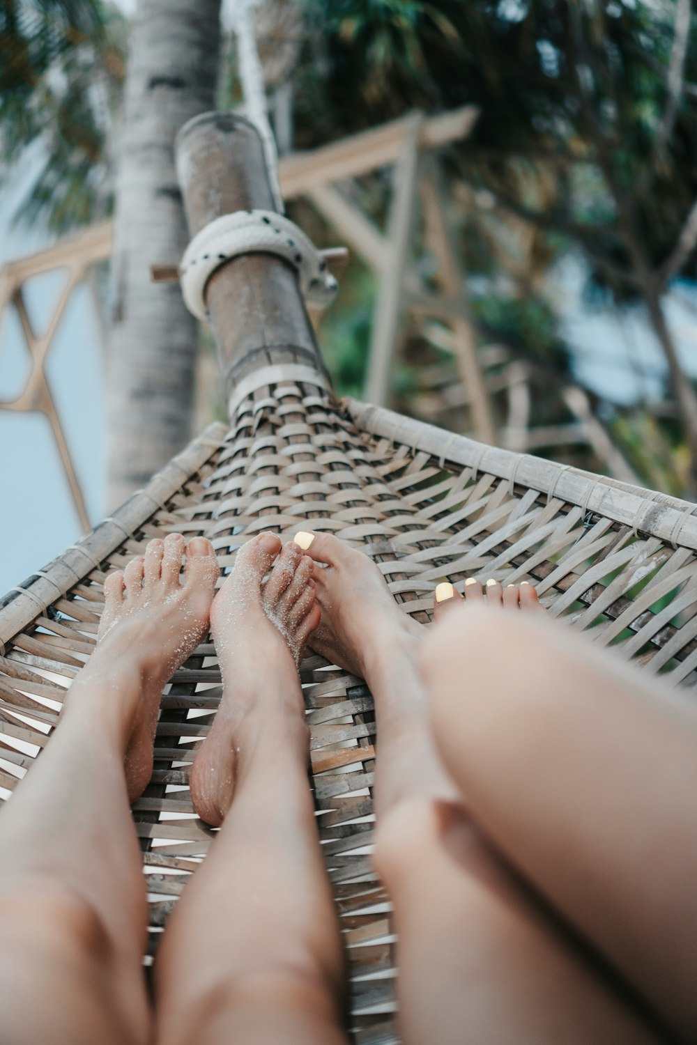 a person laying in a hammock on the beach