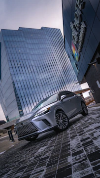 A sleek corporate shuttle van arriving at a business center with professionals stepping out.