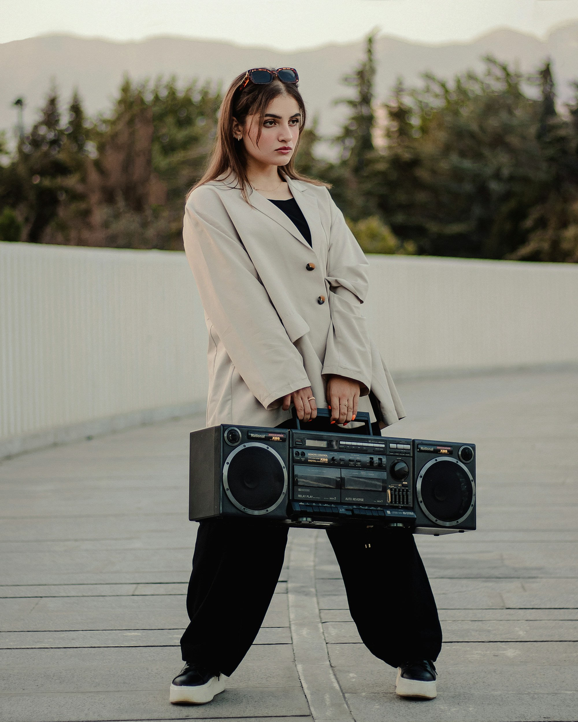a woman is holding a boombox and posing for a picture