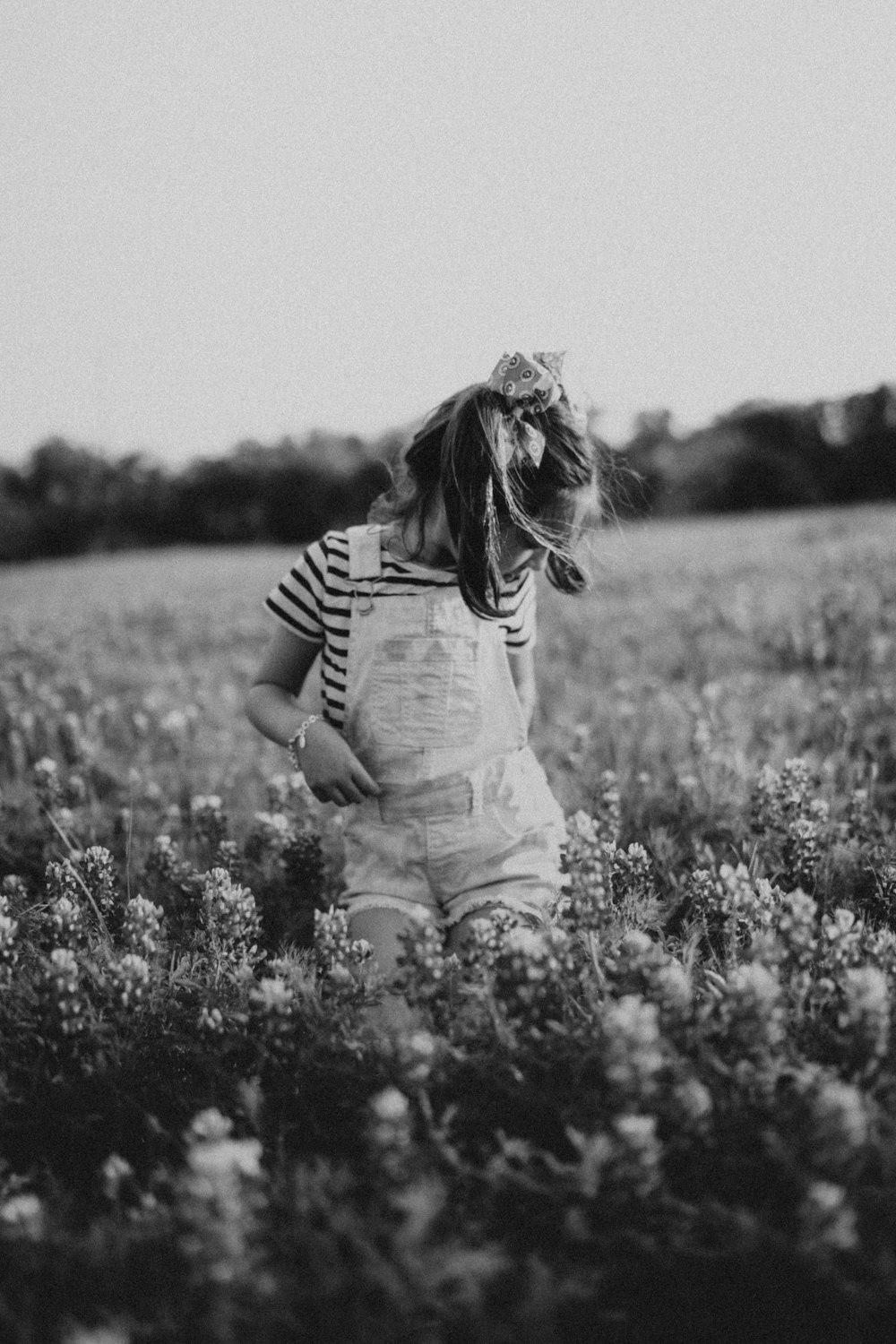 a little girl standing in a field of flowers