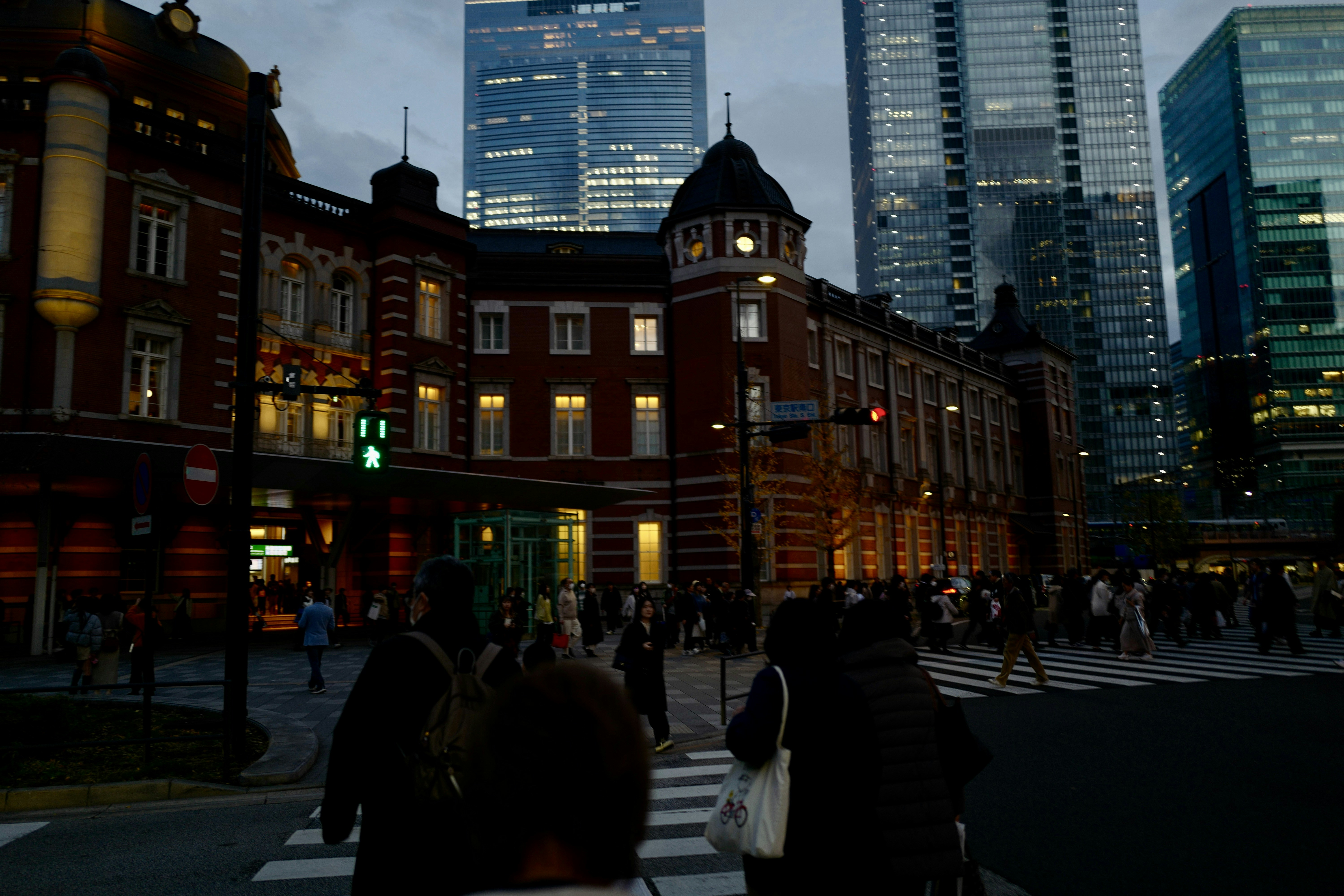 a group of people walking across a cross walk, 