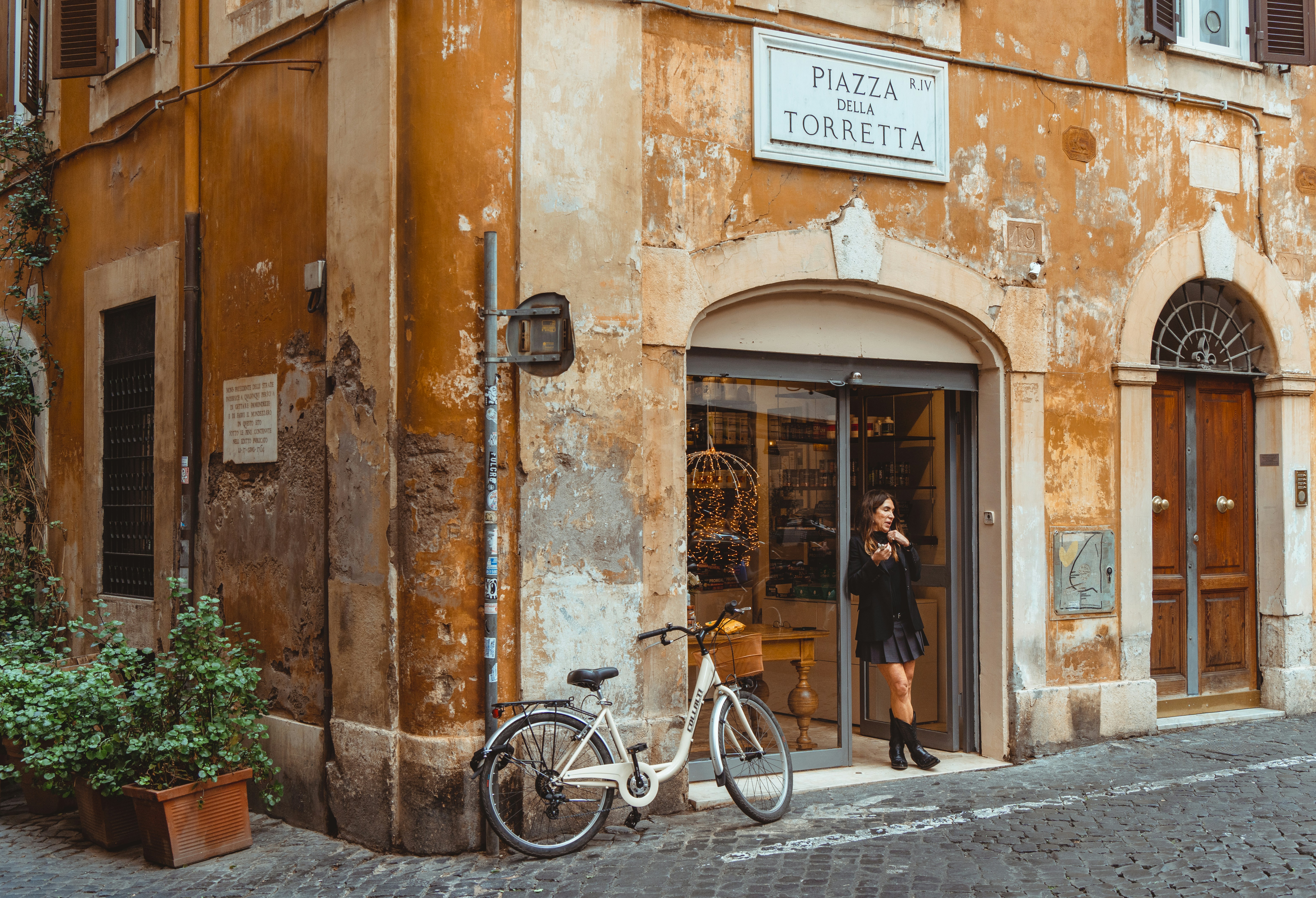 a woman standing in a doorway of a building, 