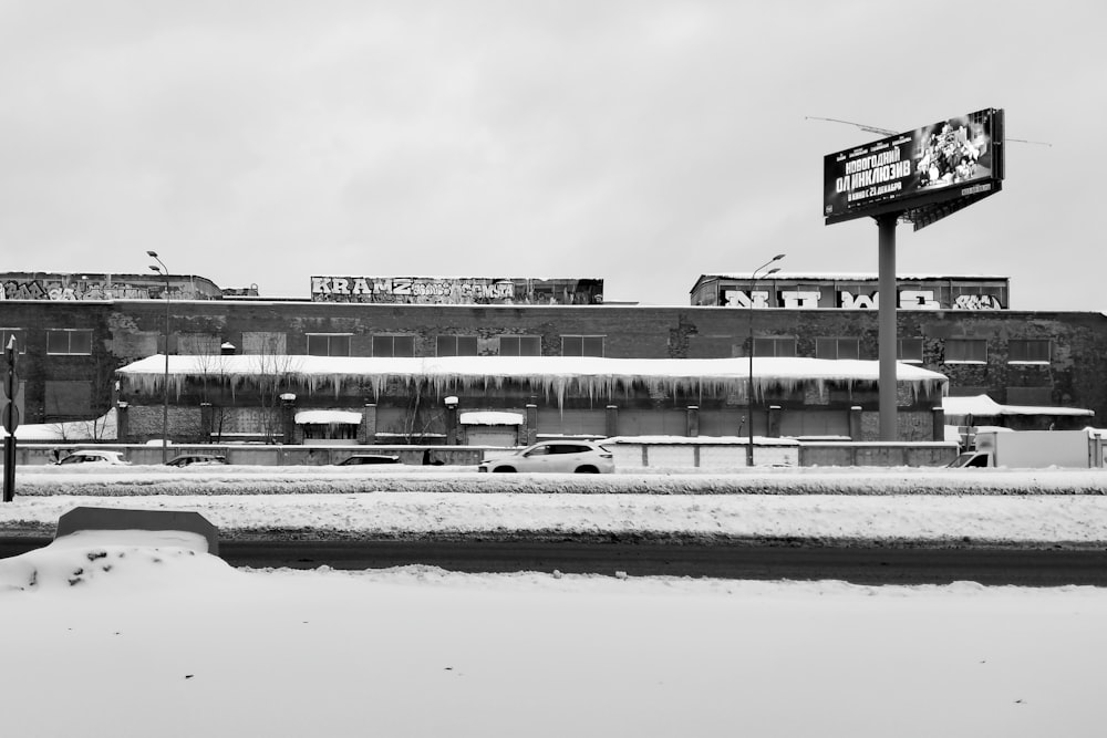 a black and white photo of a snow covered parking lot