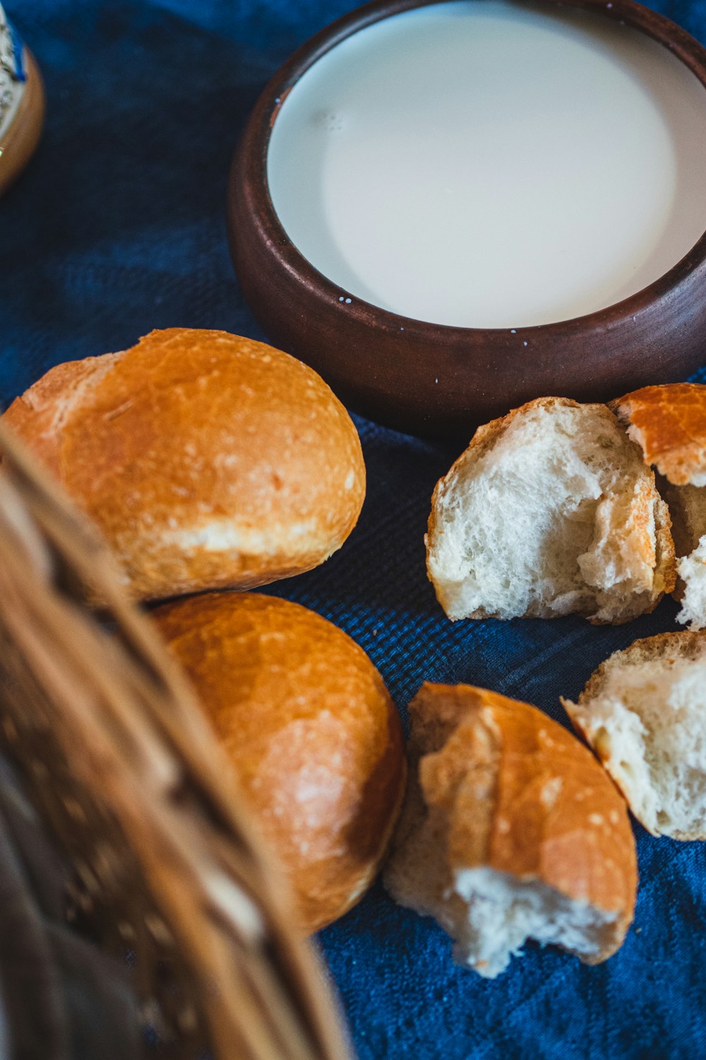 una canasta de pan junto a un tazón de leche