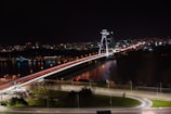 A panoramic view of the Story Bridge lit up at night over the Brisbane River