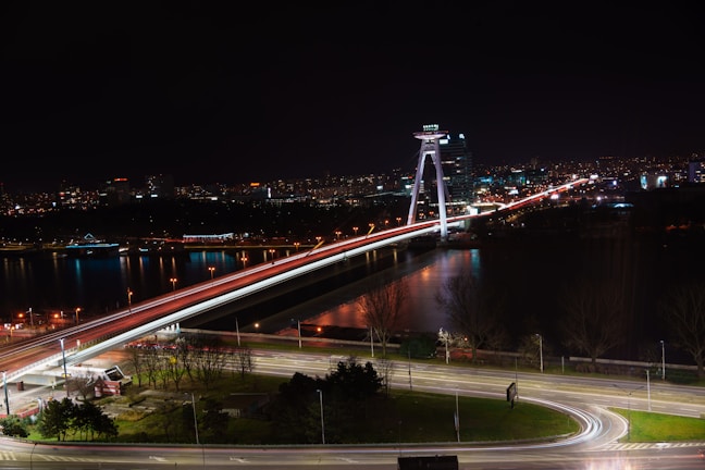 A panoramic view of the Story Bridge lit up at night over the Brisbane River