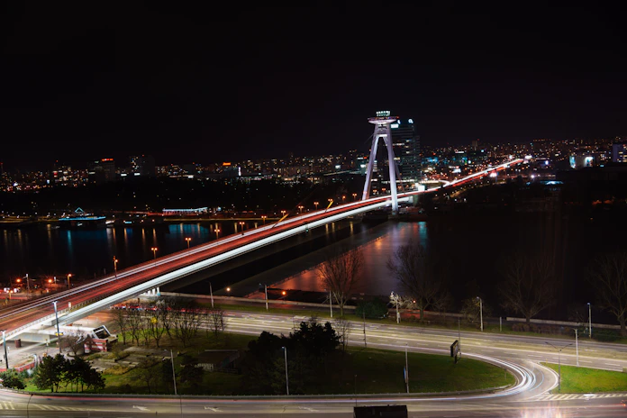 Night view of a cityscape highlighting illuminated bridges and structures.