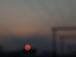 Close-up of a translucent card overlay with blurred background of a sunset over Cartagena’s expanding zone.