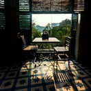Bright seating area by the window with a small wooden table and chairs.