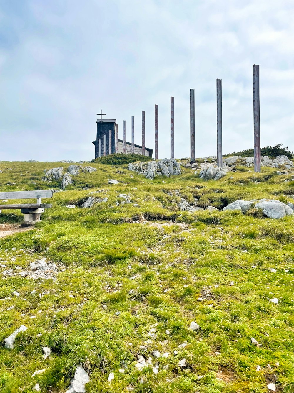 a grassy hill with benches and a tower in the background