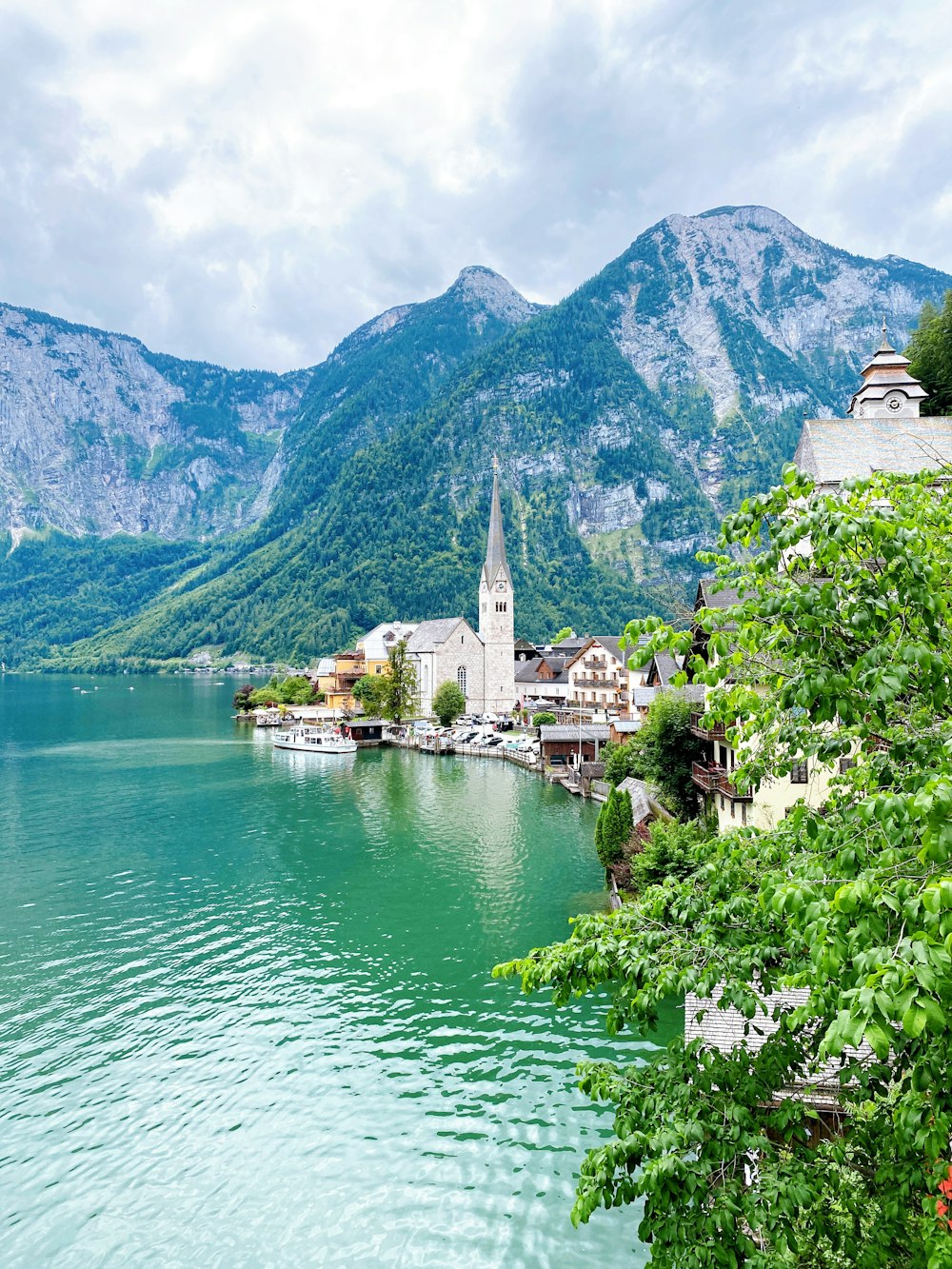 a lake surrounded by mountains with a church in the middle