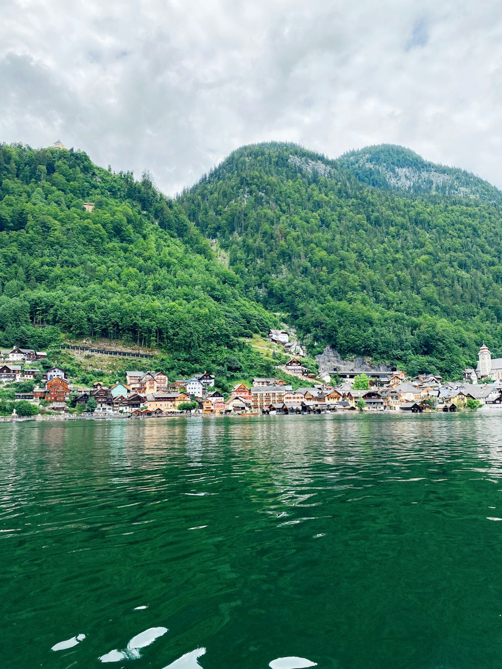 a small village on the side of a mountain next to a body of water