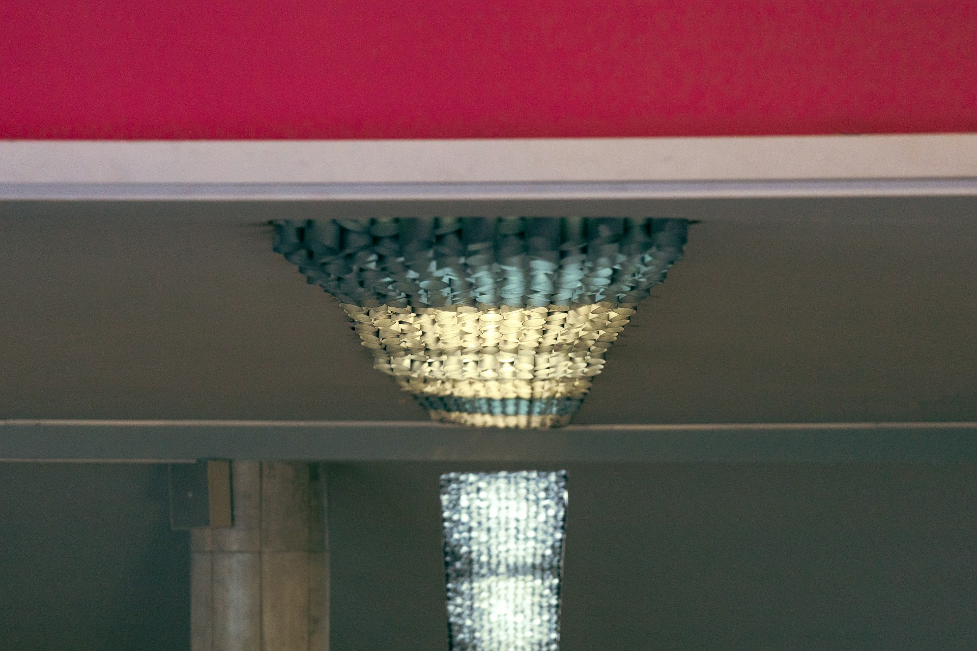 An artistic ceiling light piece blending metal and glass, creating a dynamic focal point in a boutique hotel lobby.