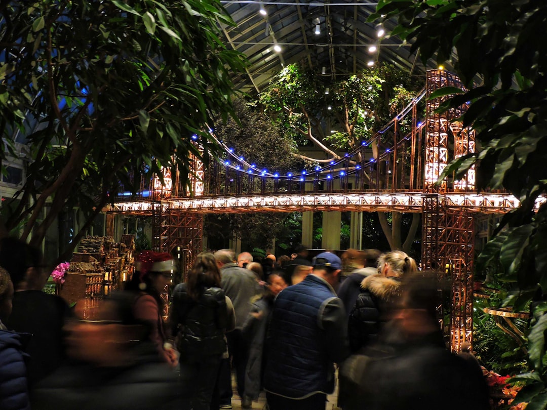 a group of people walking through a garden,