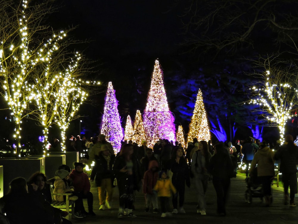 a group of people standing in front of christmas trees