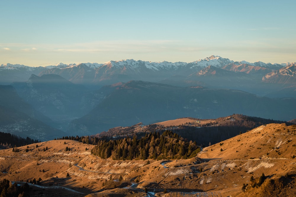 a scenic view of a mountain range with trees and mountains in the background